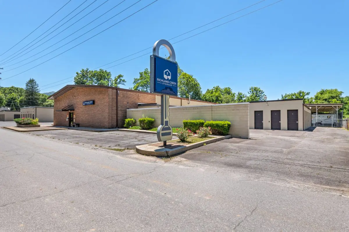 A parking lot with a blue sign and buildings