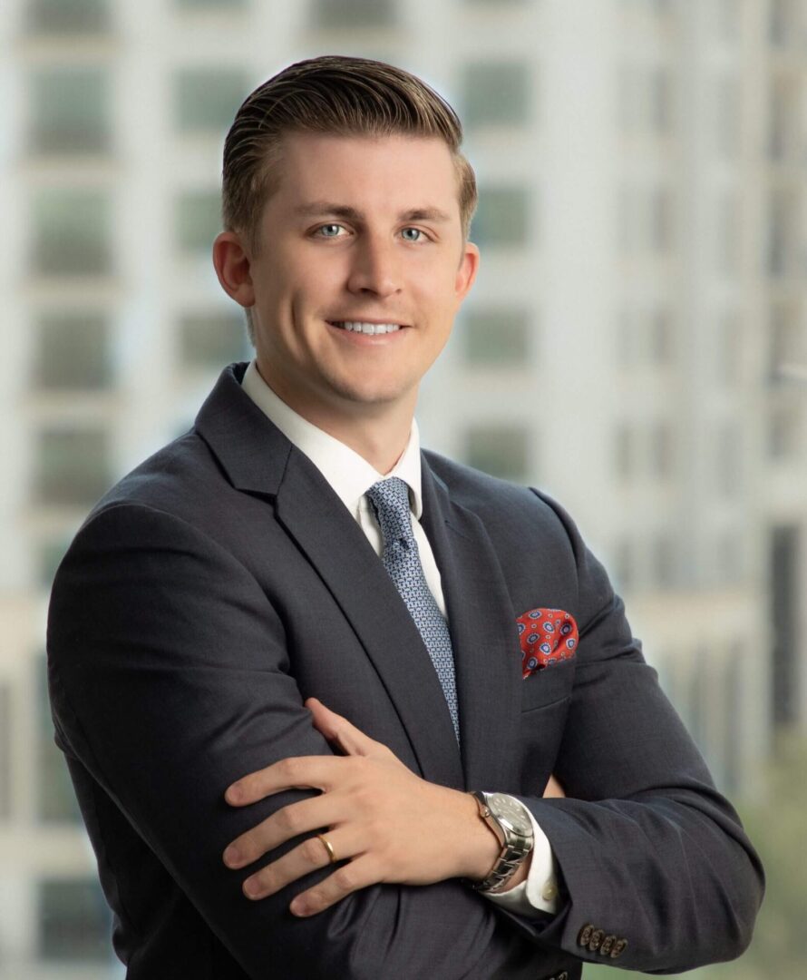 A man in suit and tie with his arms crossed.