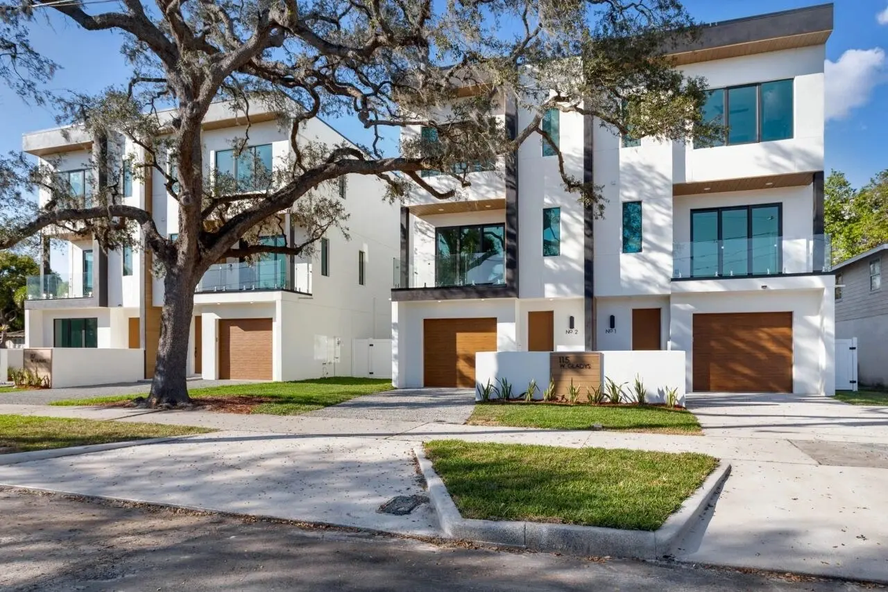 A row of houses with trees in the background.